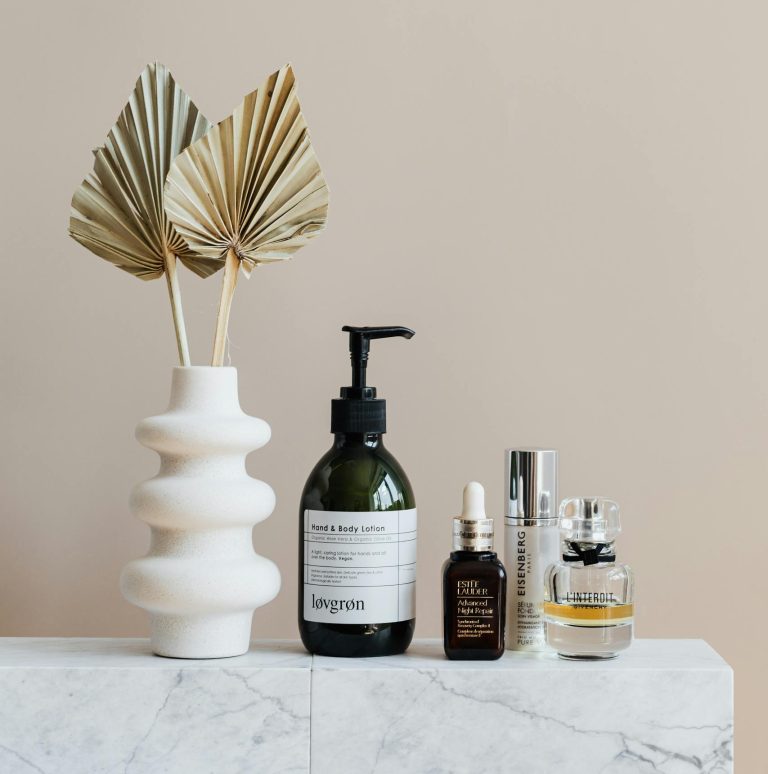 Minimalist bathroom shelf featuring skincare bottles and decorative beige vase.
