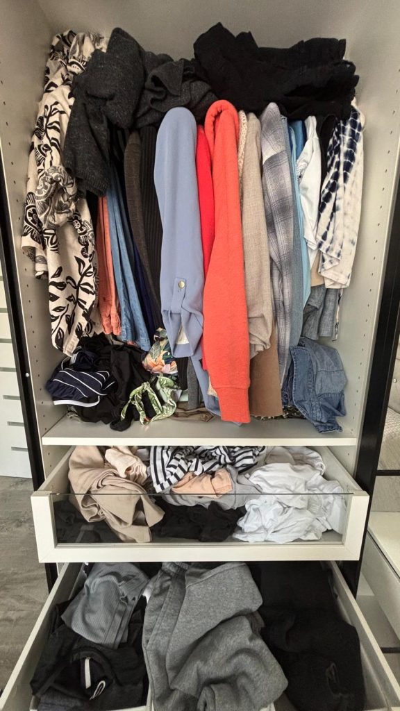 Small closet overflowing with clothes and difficult to organize