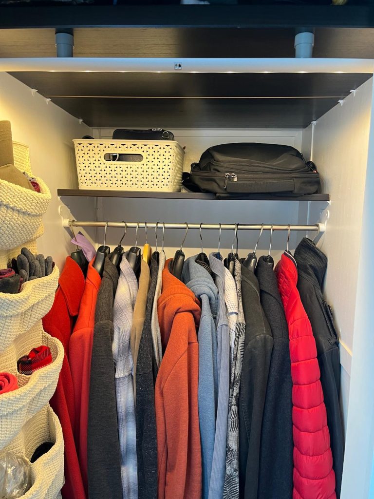 Organized small closet with everyday clothes neatly arranged