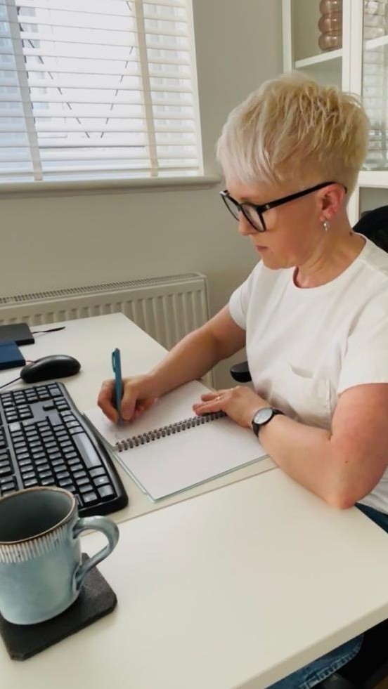 Home organiser making notes to review clients space and create a personalised plan